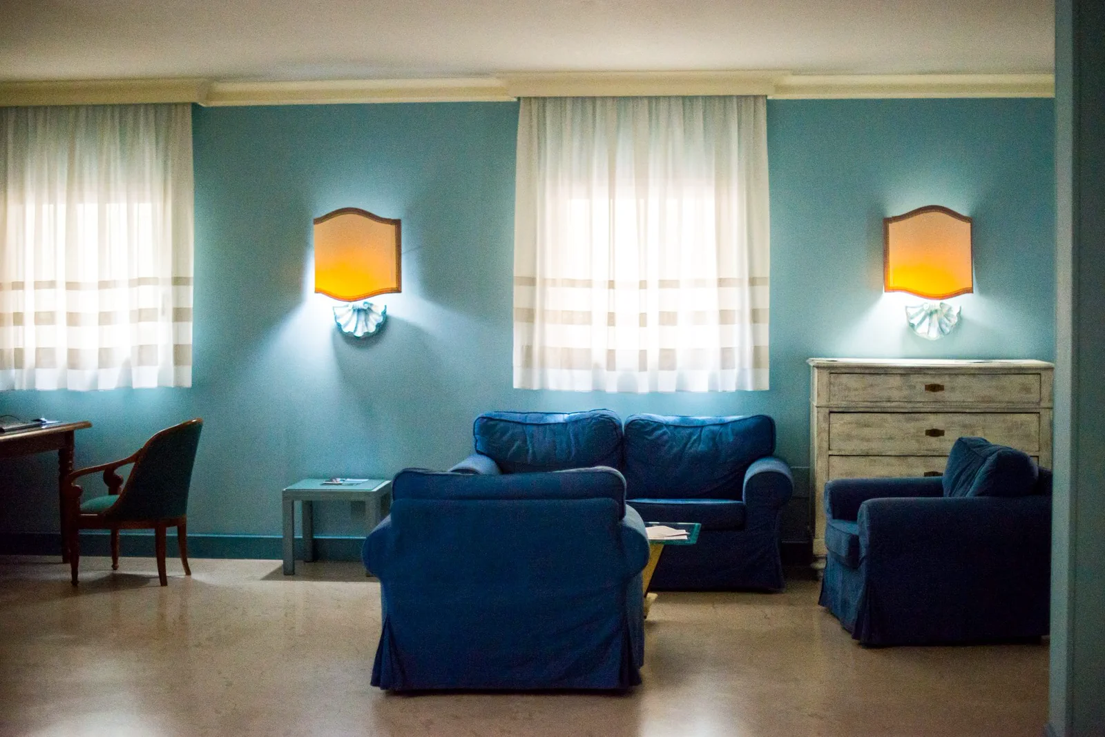The Hotel Diana lounge, with blue armchairs and daylight from the windows