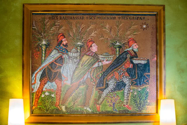 Riproduzione del mosaico dei Re Magi appesa fra due lampade in hotel