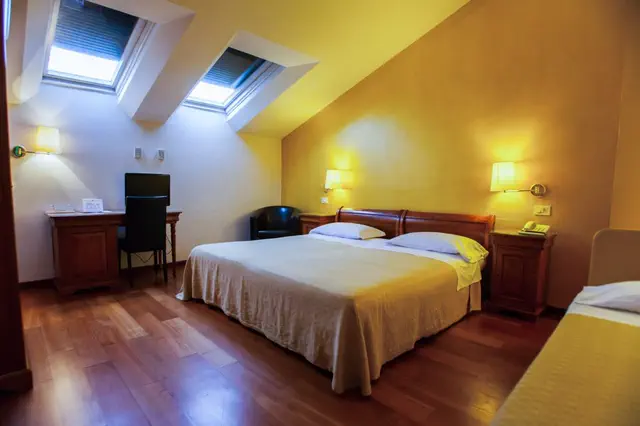 Camera mansardata con due lucernari, letto matrimoniale e scrivania